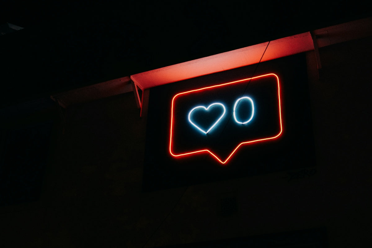 A red neon speech bubble sign containing a blue heart and a zero
