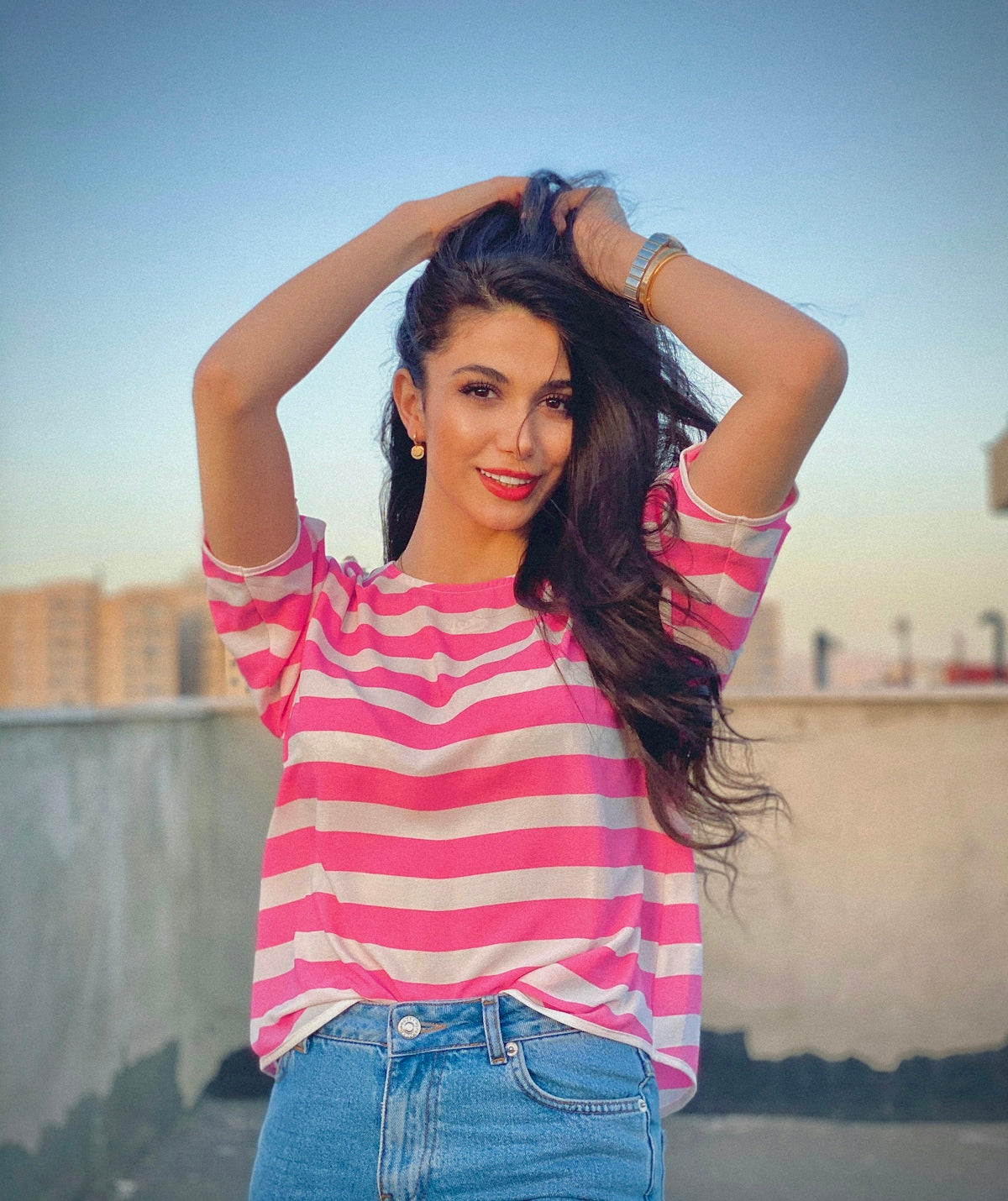 woman in pink and white striped shirt and blue denim shorts