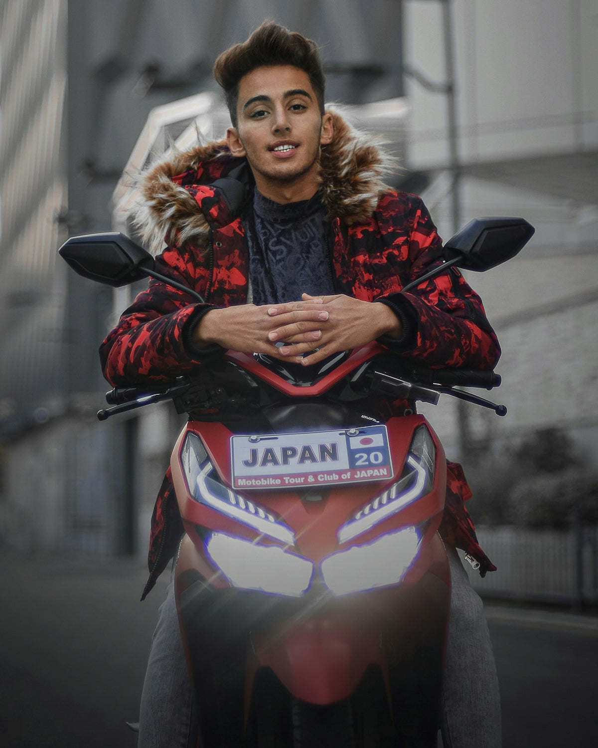 a man in a red and black jacket is sitting on a red motorcycle