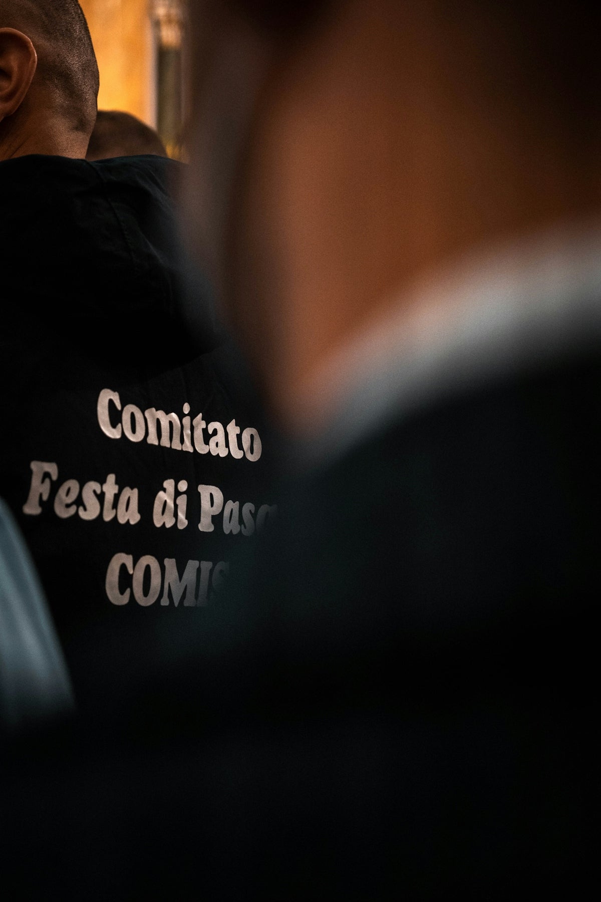 a man in a black shirt looking at his reflection in a mirror