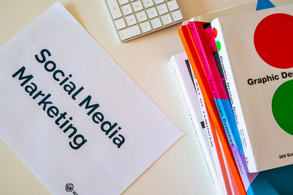a sign that says social media marketing next to a keyboard