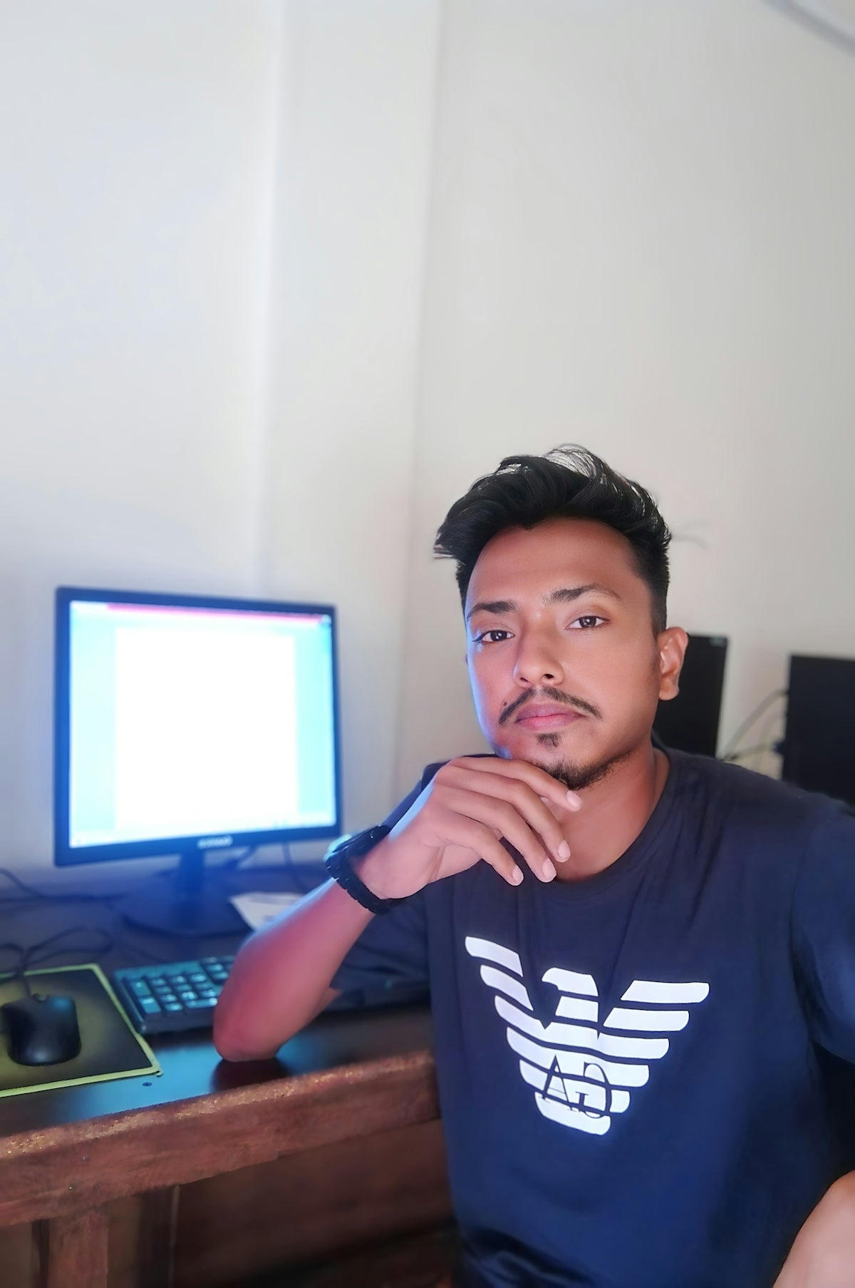 A man sitting in front of a computer monitor