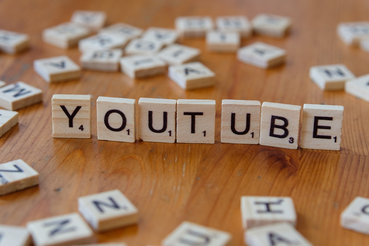 A wooden block spelling out the word youtube on a table