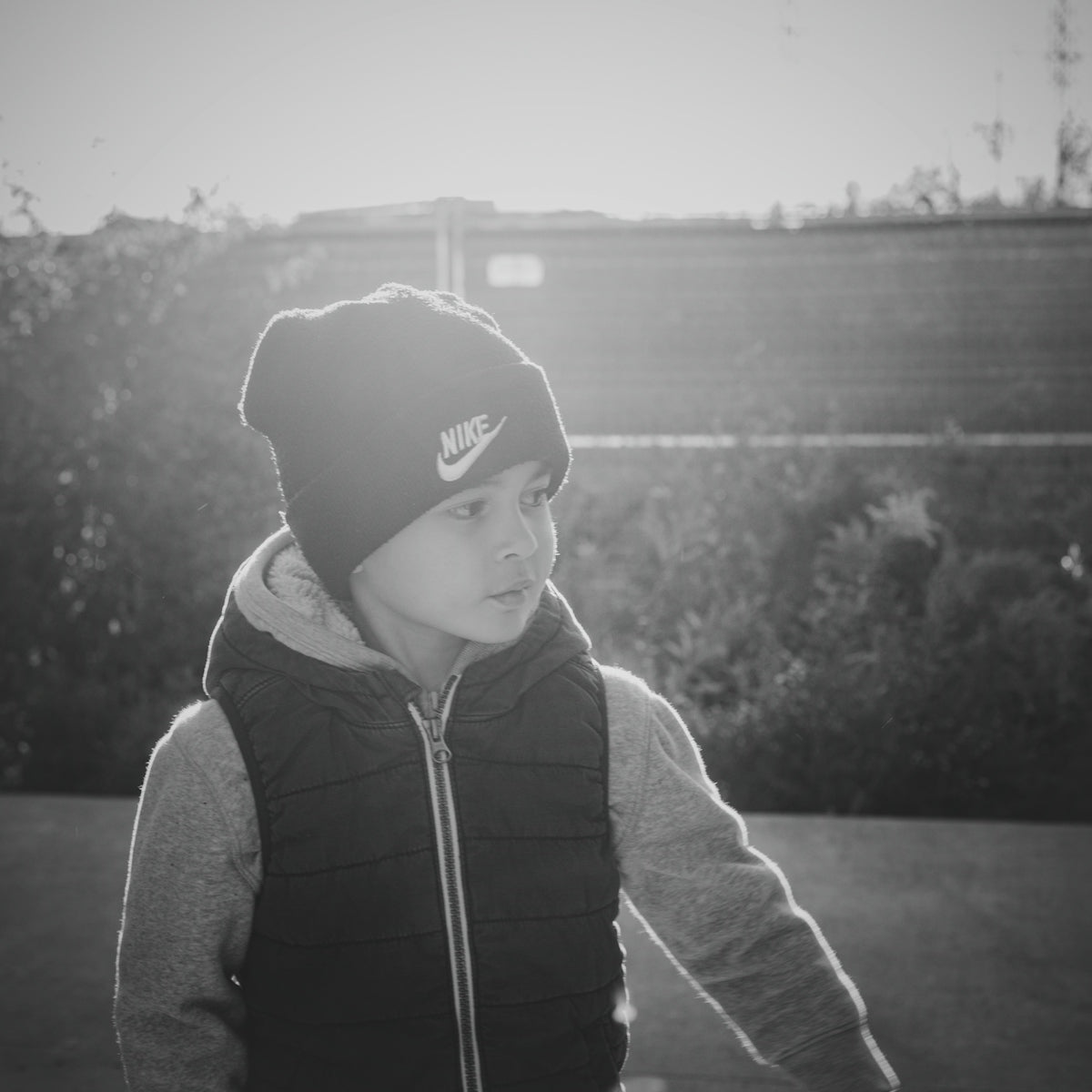Young boy wearing a beanie and vest outdoors