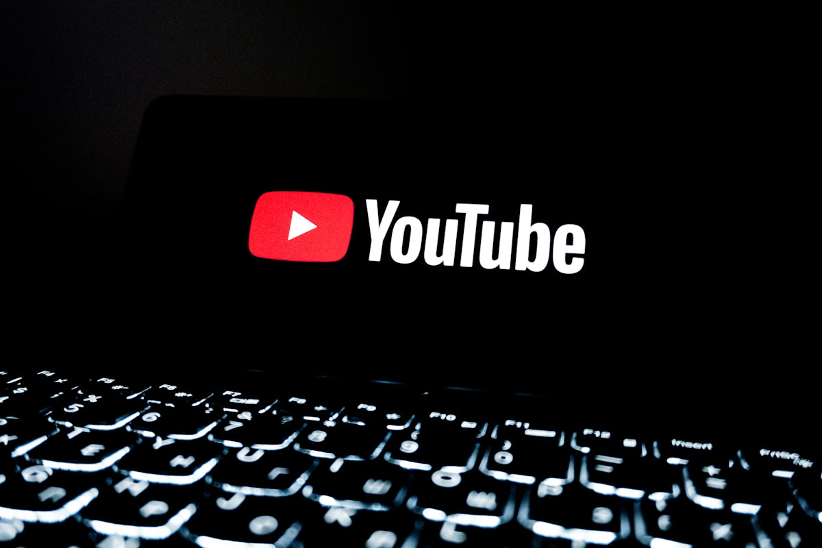 Youtube logo displayed on a dark screen above keyboard
