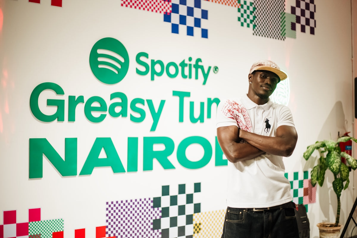 Man poses against a colorful spotify greasy turnip nairobi background.